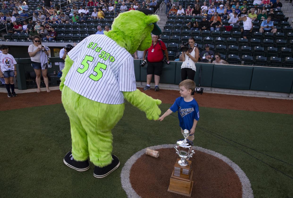 Sluggo, the Eugene Emeralds mascot, greets 4-year-old Axel Job before the young baseball fan got to call out "play ball" over the loudspeaker to start at new season for the Ems in 2019.