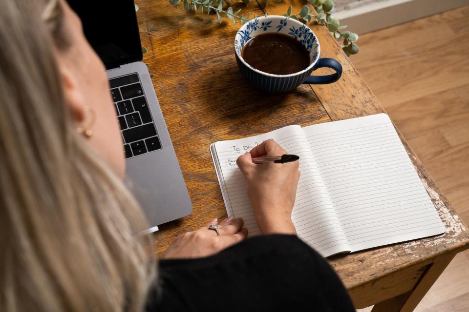 close up of woman writing to do list in notepad