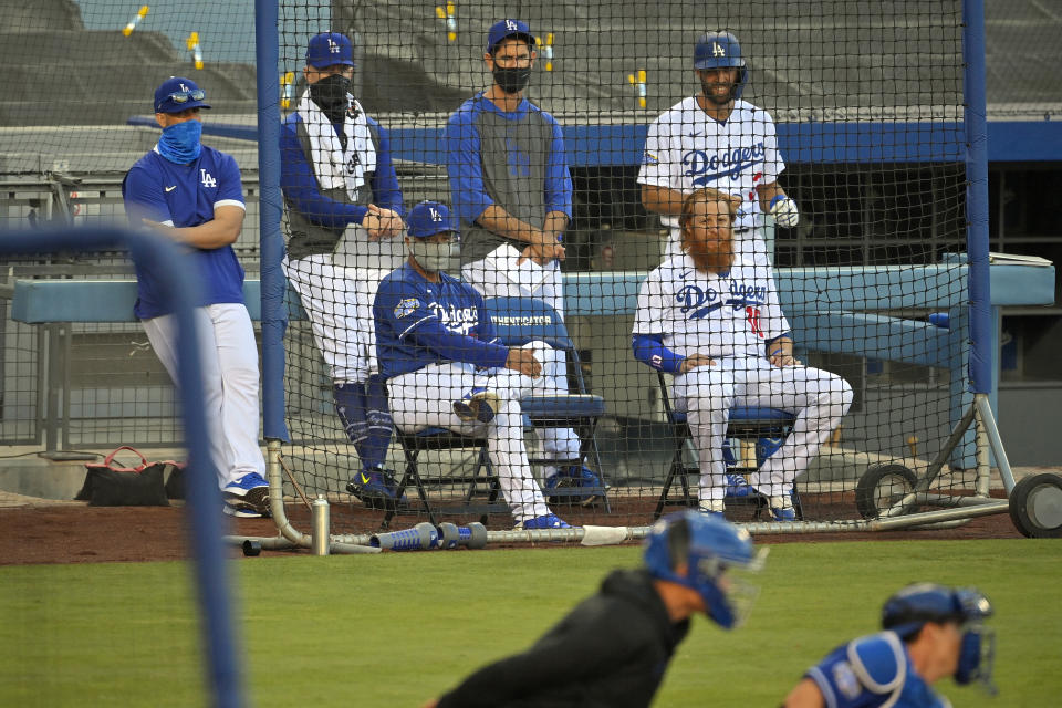 Los Angeles Dodgers manager Dave Roberts, center left, and Justin Turner, center right, watch along with other members of the team during an intrasquad baseball game Thursday, July 9, 2020, in Los Angeles. (AP Photo/Mark J. Terrill)