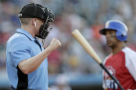 Home plate umpire Brian deBrauwere, left, calls a strike given to him by a radar system over an earpiece as Liberty Division's Tyler Ladendorf, right, of the High Point Rockers, strikes out to Freedom Division's Mitch Atkins, of the York Revolution, during the first inning of the Atlantic League All-Star minor league baseball game, Wednesday, July 10, 2019, in York, Pa. deBrauwere wore the earpiece connected to an iPhone in his ball bag which relayed ball and strike calls upon receiving it from a TrackMan computer system that uses Doppler radar. The independent Atlantic League became the first American professional baseball league to let the computer call balls and strikes during the all star game. (AP Photo/Julio Cortez)