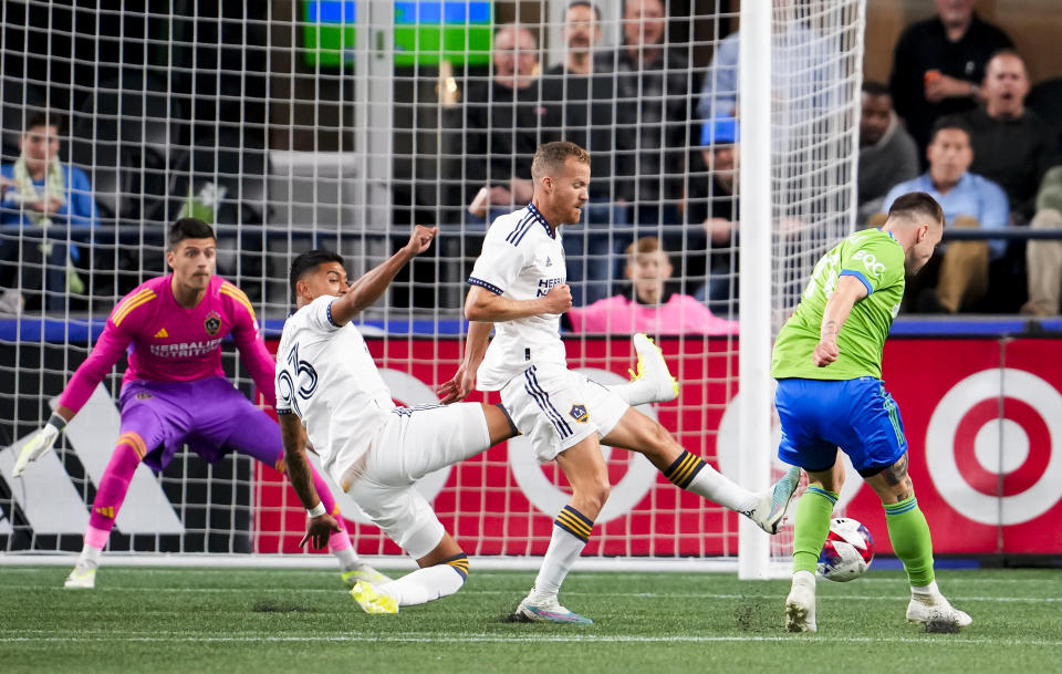 LA Galaxy defender Tony Alfaro (93) and midfielder Oriol Rosell, center, defend against a shot from Seattle Sounders midfielder Albert Rusnák, right, during the first half of an MLS soccer match Wednesday, Oct. 4, 2023, in Seattle. (AP Photo/Lindsey Wasson)