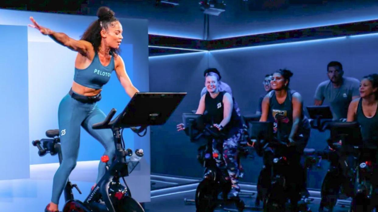  Woman giving class at Peloton Studios London . 