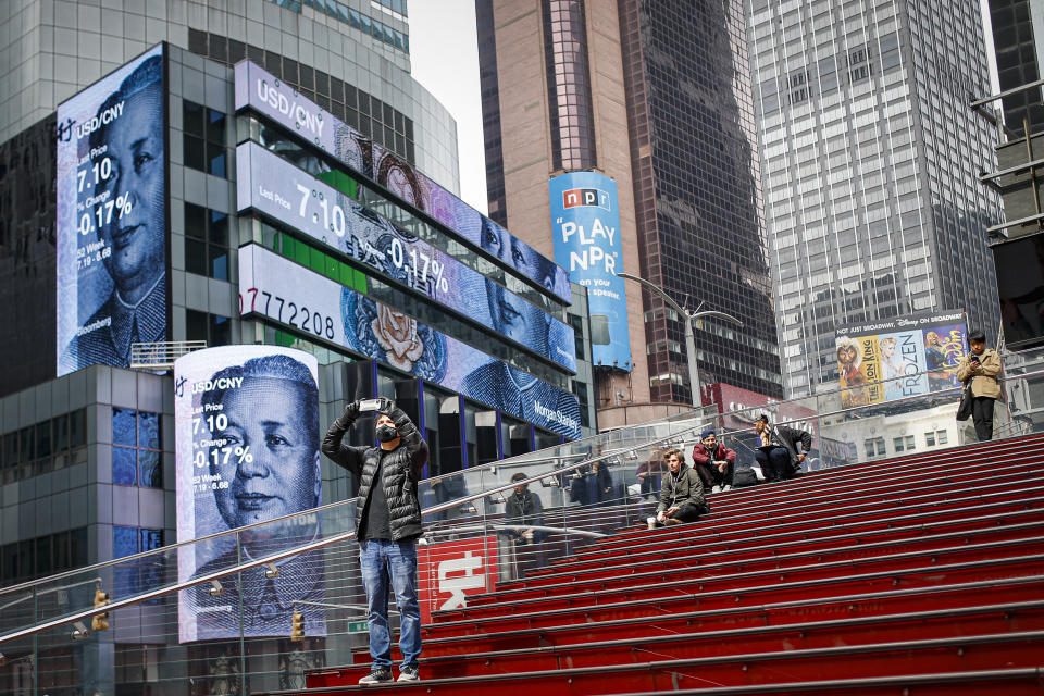 FILE - This March 20, 2020 file photo shows pedestrians in a sparsely populated Times Square in New York. COVID-19 has shaken theater fans and shuttered all New York City's venues, including Broadway, which grossed $1.8 billion last season and attracted a record 15 million people. How Broadway — one the city's jewels — will reopen is still not clear. (AP Photo/John Minchillo, File)