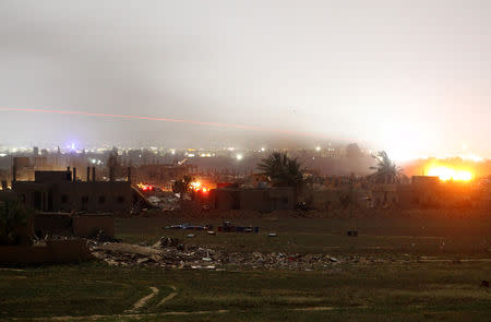 Fire and smoke are seen during fighting in the Islamic State's final enclave, in the village of Baghouz, Deir Al Zor province, Syria March 17, 2019. REUTERS/Stringer