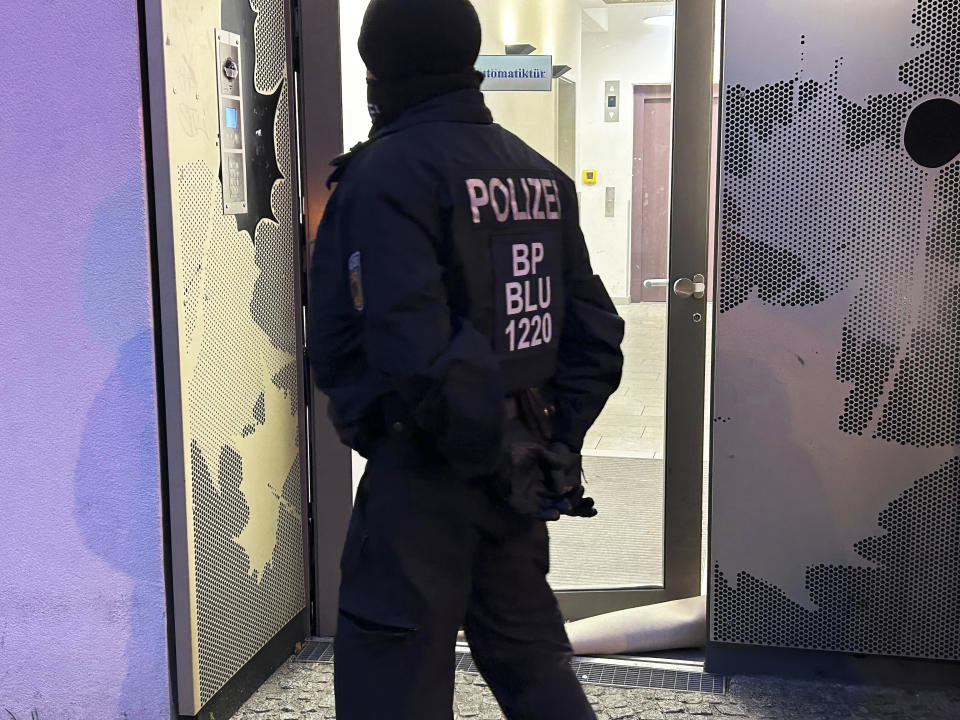 A police officer stands in front of a building during a raid in Berlin-Adlershof in Berlin, Thursday, Nov. 23, 2023. Hundreds of police officers searched the properties of Hamas members and followers in Germany on Thursday morning with the majority of the raids taking place in Berlin.(Sven Kaeuler/dpa via AP)