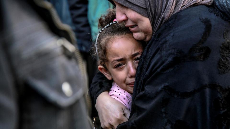 PHOTO: A Palestinian woman holds a child as they mourn their relatives killed in Israeli bombardment in front of the morgue of the Al-Shifa hospital in Gaza City, Mar. 15, 2024. (AFP via Getty Images)