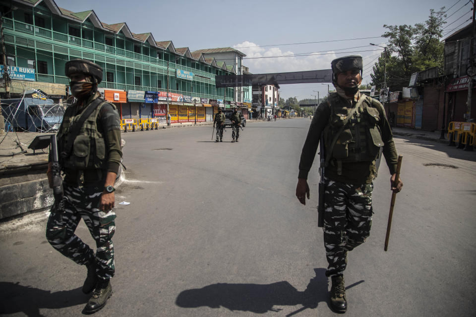 CORRECTS AGE - Indian paramilitary soldiers patrol a deserted market area in Srinagar, Indian controlled Kashmir, Thursday, Sept. 2, 2021. Indian authorities cracked down on public movement and imposed a near-total communications blackout Thursday in disputed Kashmir after the death of Syed Ali Geelani, a top separatist leader who became the emblem of the region’s defiance against New Delhi. Geelani, who died late Wednesday at age 91, was buried in a quiet funeral organized by authorities under harsh restrictions, his son Naseem Geelani told The Associated Press. He said the family had planned the burial at the main martyrs’ graveyard in Srinagar, the region’s main city, as per his will but were disallowed by police. (AP Photo/ Mukhtar Khan)