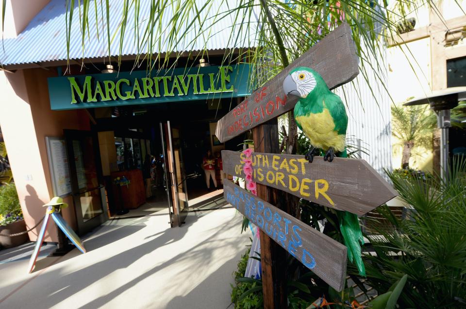 A Margaritaville sign on a building next to fake tropical signs