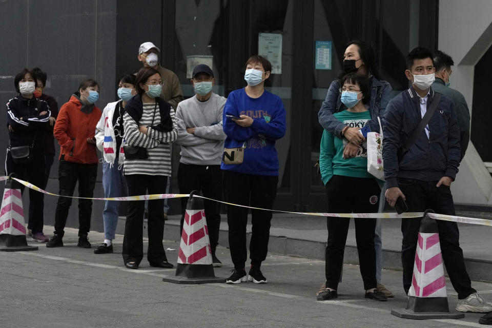 Residents line up for COVID test, Wednesday, April 27, 2022, in Beijing. Workers put up fencing and police restricted who could leave a locked-down area in Beijing on Tuesday as authorities in the Chinese capital stepped up efforts to prevent a major COVID-19 outbreak like the one that has all but shut down the city of Shanghai. (AP Photo/Ng Han Guan)