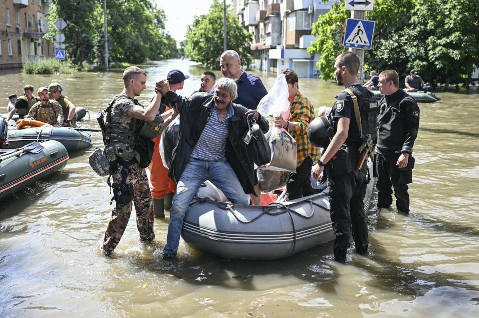 Officials help people on June 7, 2023, after the explosion at the Kakhovka hydropower plant flooded the houses and streets in Kherson, Ukraine. <a href="https://www.gettyimages.com/detail/news-photo/officials-help-people-to-evacuate-their-homes-after-the-news-photo/1258499269?adppopup=true" rel="nofollow noopener" target="_blank" data-ylk="slk:Ercin Erturk/Anadolu Agency via Getty Images;elm:context_link;itc:0;sec:content-canvas" class="link ">Ercin Erturk/Anadolu Agency via Getty Images</a>