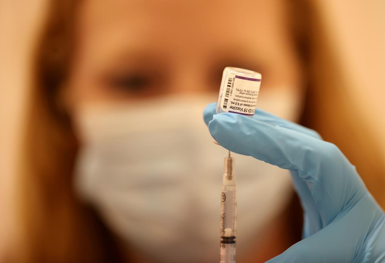 A Safeway pharmacist fills a syringe with the Pfizer COVID-19 booster vaccination in San Rafael, Calif. 