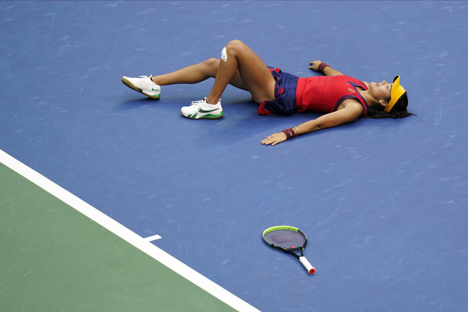 Emma Raducanu, of Britain, lies on the court after defeating Leylah Fernandez, of Canada, during the women's singles final of the US Open tennis championships, Saturday, Sept. 11, 2021, in New York. (AP Photo/Frank Franklin II)