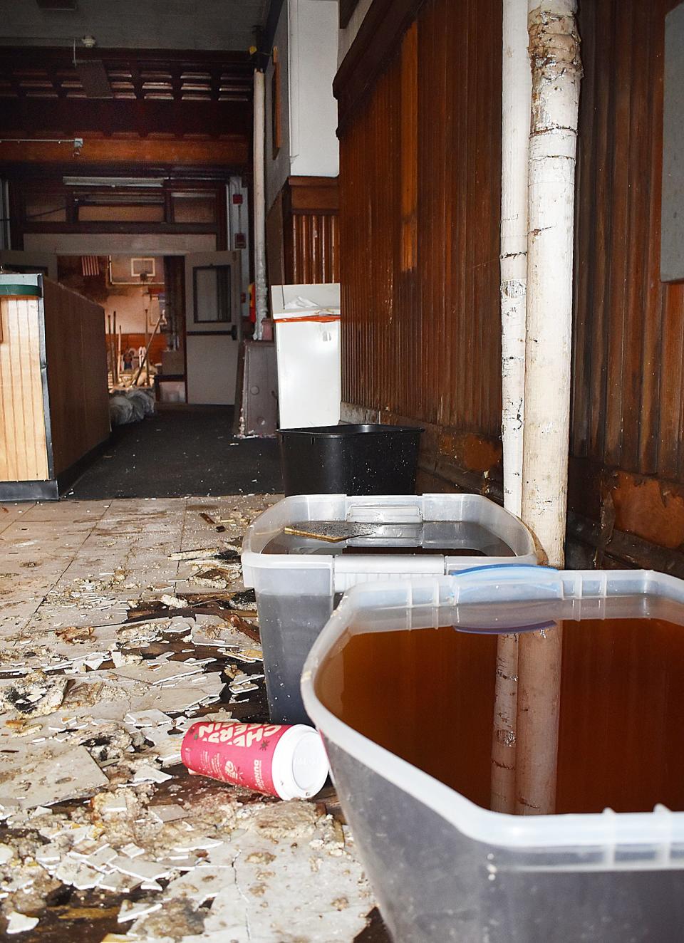 The Bank Street Armory, on Bank Street in Fall River, is in rough condition, with trash, debris and bins of water.