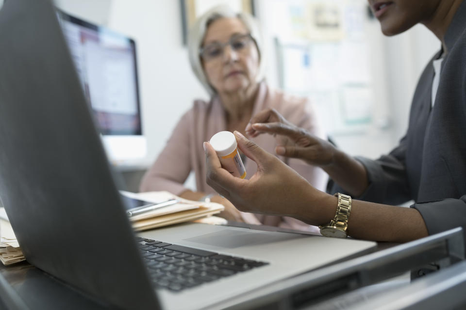 Female doctor prescribing mediation to senior patient in clinic office