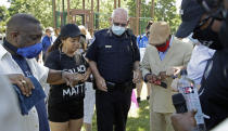 Local Pastors touch elbows with Fairfield Police Chief Walter Tibbet, center, during 'Taking a knee for Justice and Prayer' service, Wednesday, June 3, 2020, in Fairfield, Calif. (AP Photo/Ben Margot)