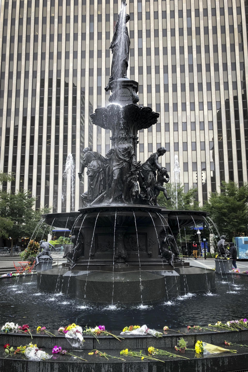 Flowers are placed at the Tyler Davidson Fountain at Fountain Square where a shooting took place on Sept. 6 that claimed the lives of three civilians, Monday, Sept. 10, 2018, in Cincinnati. The motives of the suspect Omar Enrique Santa Perez are still under investigation. (AP Photo/Dan Sewell)