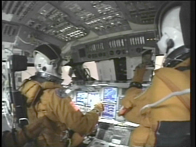 Using a hand-held video camera, astronaut Laurel Clark recorded the pink glow out Columbia's cockpit windows as the shuttle began encountering the heat of re-entry high above the Pacific Ocean. / Credit: NASA