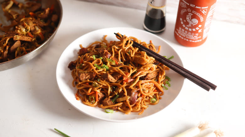 roasted pork lo mein with chopsticks on plate