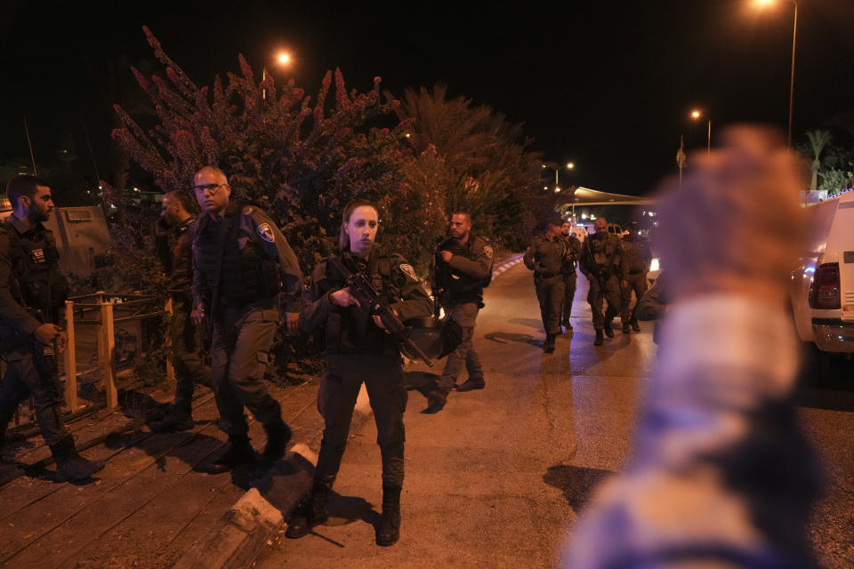 Israeli border police officers patrol next to the scene of a shooting attack outside the Israeli settlement of Maale Adumim, in the West Bank, Wednesday, Oct. 19, 2022. A Palestinian gunman who killed an Israeli soldier earlier this month was killed Wednesday after opening fire at a security guard at a West Bank settlement near Jerusalem. Israel Prime Minister Yair Lapid said Wednesday that Uday Tamimi, a Palestinian man from the Shuafat refugee camp near Jerusalem who was the subject of a more than weeklong manhunt by security forces, was killed by Israeli security forces. Police said he opened fire at a security guard, wounding him lightly. (AP Photo/Mahmoud Illean)