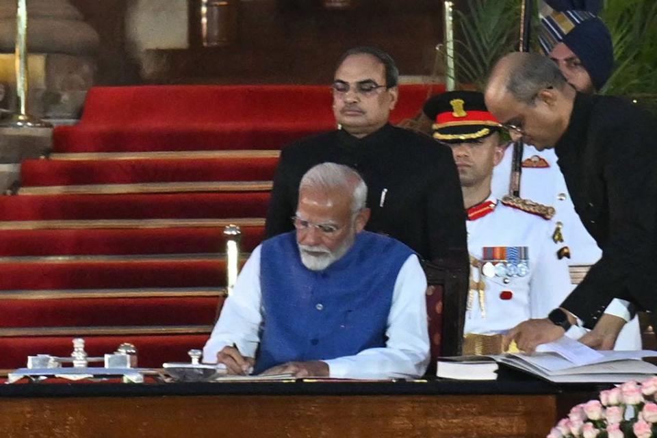 India's Bharatiya Janata Party (BJP) leader, Narendra Modi (L) signs after taking the oath of office for a third term as the country's Prime Minister during the oath-taking ceremony at presidential palace Rashtrapati Bhavan in New Delhi on June 9, 2024. India's Prime Minister Narendra Modi was sworn in on June 9, for a third term after worse-than-expected election results left him reliant on coalition partners to govern. (Photo by Money SHARMA / AFP) (Photo by MONEY SHARMA/AFP via Getty Images)