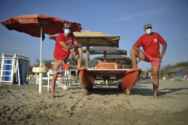 PISA, ITALY - MAY 24:  Lifeguards on the beach wearing a protective mask stands in the 'Oasi del Mare' bathhouse near Pisa on May 25, 2020 in Pisa, Italy. From 18 May access to the sea is allowed, with strict rules region by region. The bathing establishments have reopened, subject to social distancing measures, after more than two months of a nationwide lockdown and following the anti-contagion rules for Coronavirus with umbrellas spaced about 3 meters apart. There have been over 229,000 reported COVID-19 cases in Italy and more than 32,000 deaths.  (Photo by Laura Lezza/Getty Images) (Photo: Laura Lezza via Getty Images)