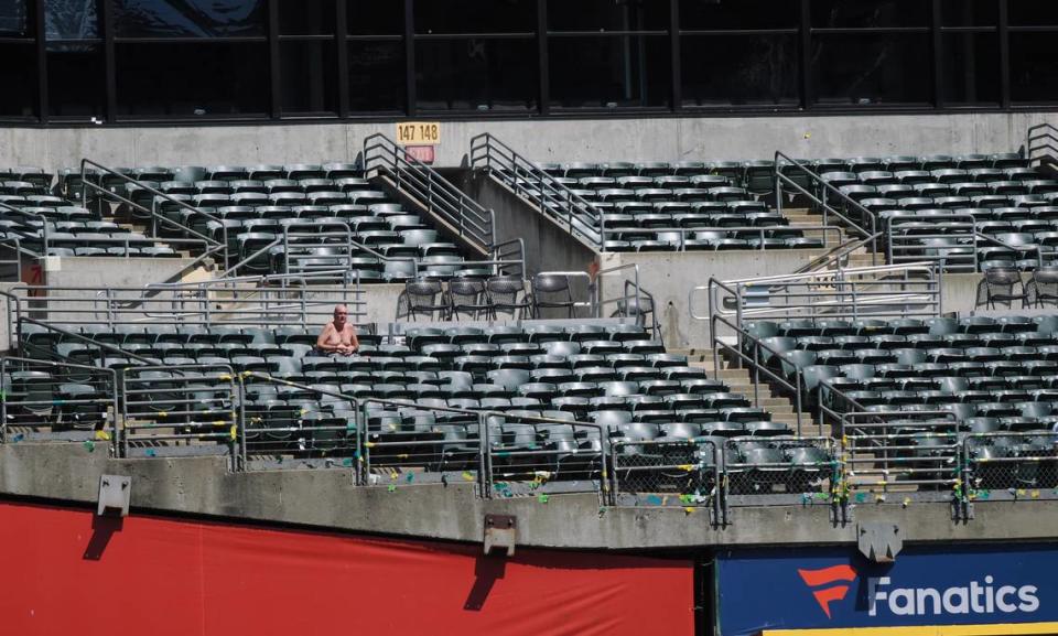 A shirtless fan sits in the stands during the eighth inning between the Oakland Athletics and Kansas City Royals at Oakland-Alameda County Coliseum.