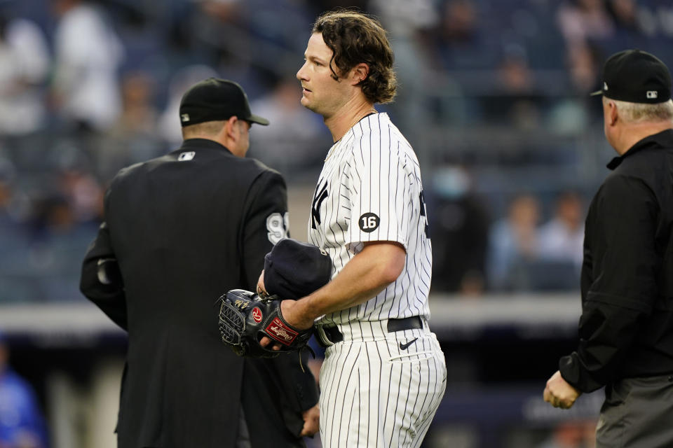 New York Yankees starting pitcher Gerrit Cole reacts after umpire Bill Miller, right, checked him for foreign substances after Cole pitched in the top of the third inning of a baseball game, Tuesday, June 22, 2021, at Yankee Stadium in New York. Home plate umpire Brian Knight is at left. (AP Photo/Kathy Willens)
