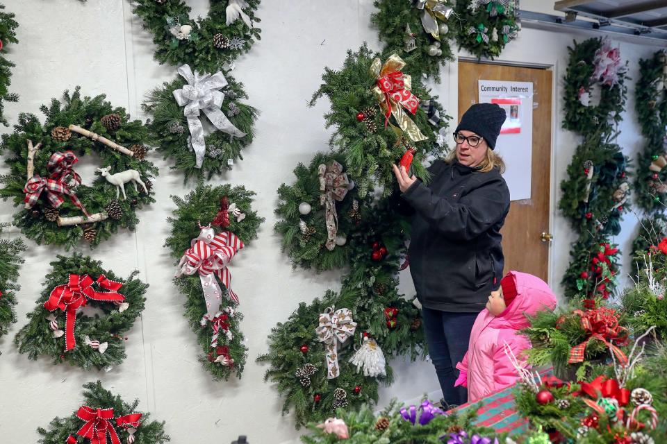 Dana Schmidt and her daughter Celia 4, shop for a wreath after cutting their Christmas tree at Candy Cane Christmas Tree Farm on Nov. 26, 2021, in Oxford, Mich.