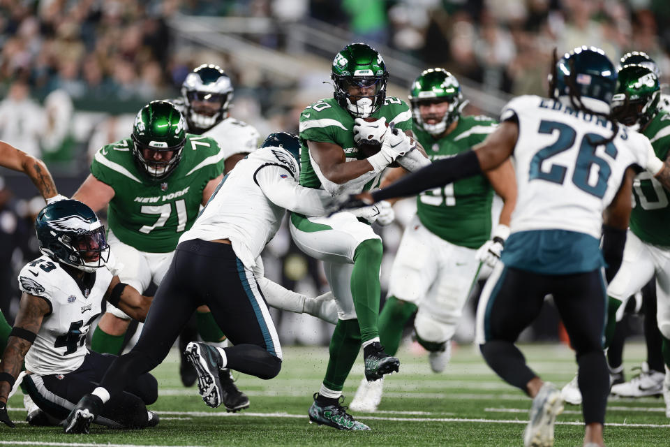 New York Jets' Breece Hall, center, runs the ball through Philadelphia Eagles defensive player during the second half of an NFL football game, Sunday, Oct. 15, 2023, in East Rutherford, N.J. (AP Photo/Adam Hunger)