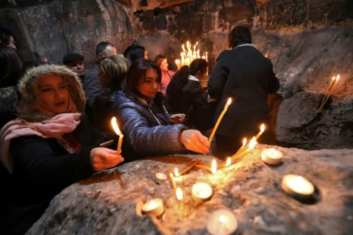 Worshippers light candles at Saint Barbara's tomb located on a rocky hill in the West Bank