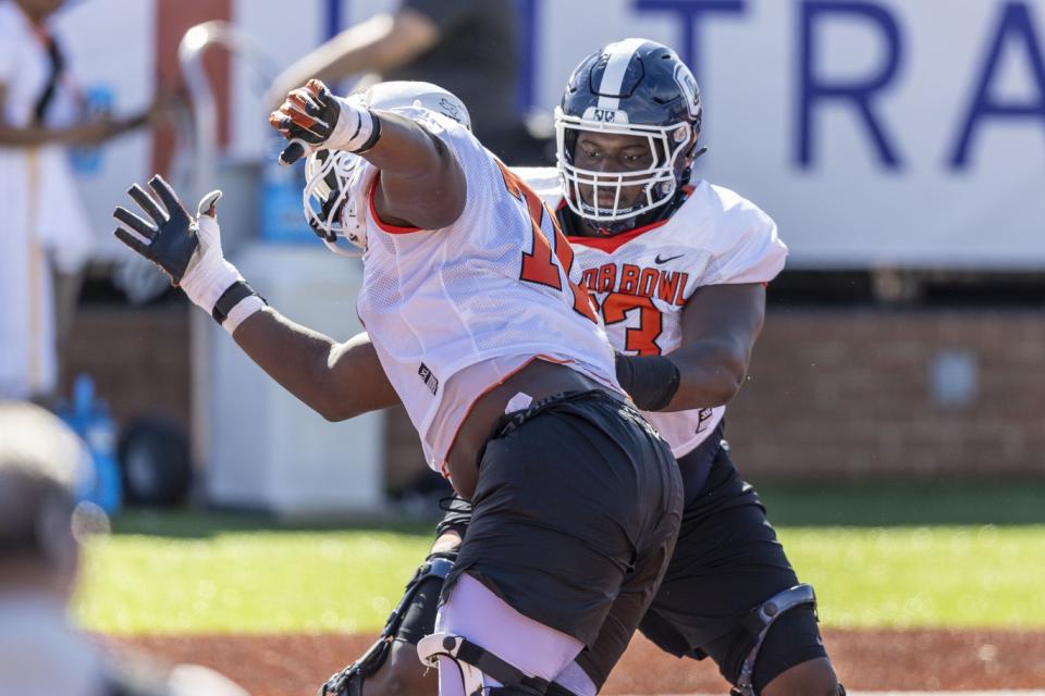 Jan 30, 2024; Mobile, AL, USA; American offensive lineman Christian Haynes of Uconn (63) faces off against American offensive lineman Christian Jones of Texas (70) during practice for the American team at Hancock Whitney Stadium. Mandatory Credit: Vasha Hunt-USA TODAY Sports