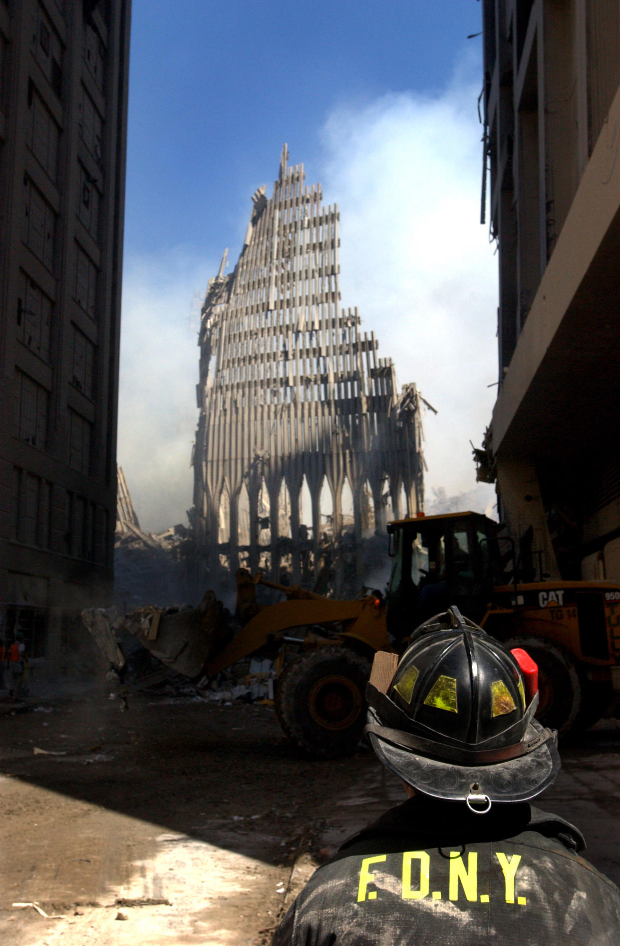 A New York City fire fighter looks up at what remains of the World Trade Center after its collapse following a Sept. 11 terrorist attack.  (U.S. Navy Photo by Photographer's Mate 2nd Class Jim Watson)