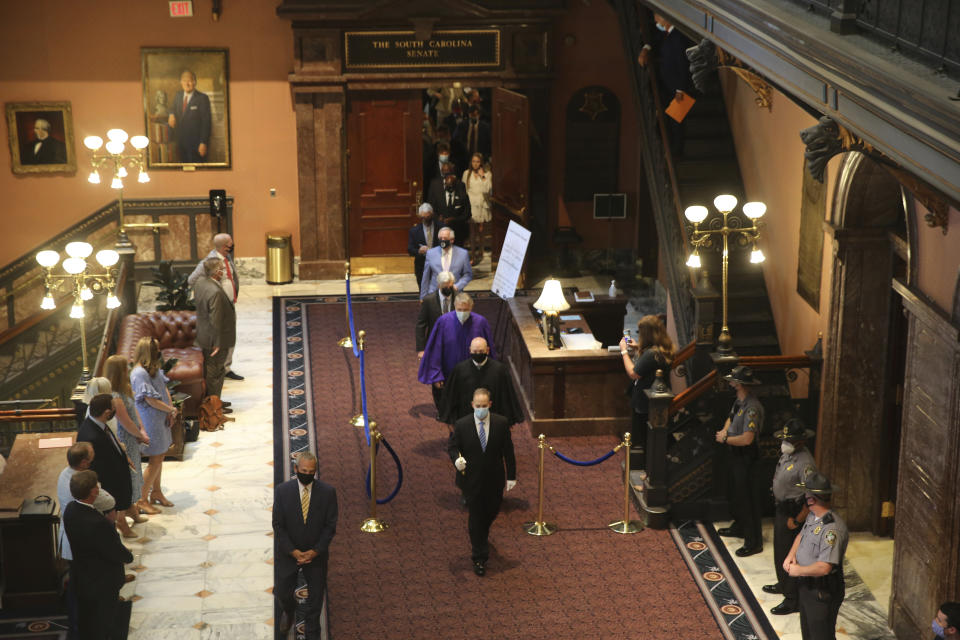 South Carolina senators walk across the Statehouse lobby for a joint session with the House on Wednesday, May 5, 2021, in Columbia, S.C. Senators sat in the balcony for the joint session because of COVID-19 concerns. (AP Photo/Jeffrey Collins)