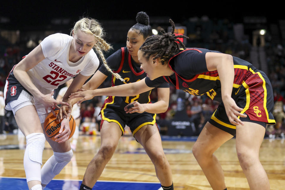 Stanford's Cameron Brink attempts to secure a rebound while defended by USC's JuJu Watkins (12) and McKenzie Forbes (25) during the Pac-12 title game. (AP Photo/Ian Maule)