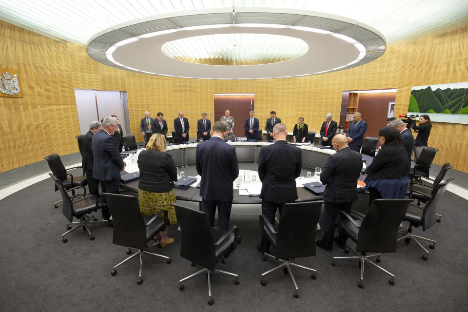 New Zealand Prime Minister Jacinda Ardern and her cabinet observe a moment of silence at the moment that a volcano erupted a week earlier, killing 18 people and leaving others with severe burns, in Wellington, New Zealand, Monday, Dec. 16, 2019. Ardern said that wherever people were in New Zealand or around the world, it was an opportunity to stand alongside those who had lost loved ones in the tragedy at White Island on Monday, Dec. 9. (Hagen Hopkins/Pool Photo via AP)