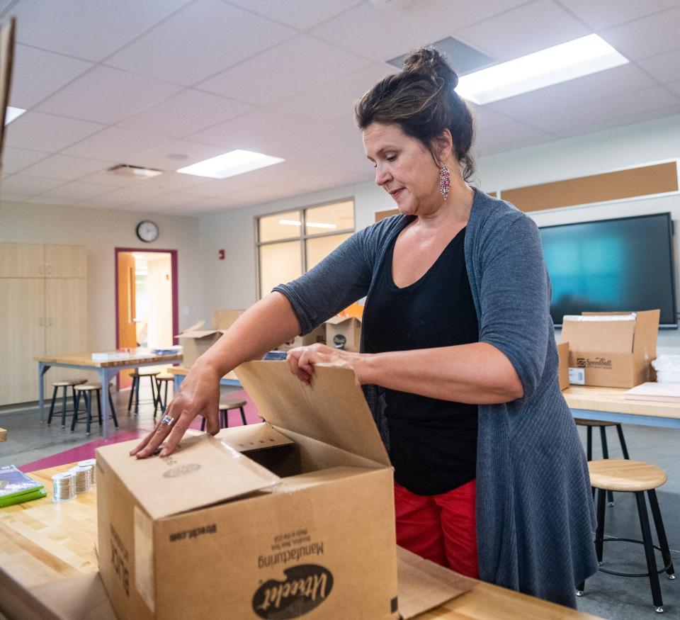 Heather Fout unloads boxes during move-in day at Minerva France Elementary School on July 18. Fout teaches kindergarten through fifth grade.