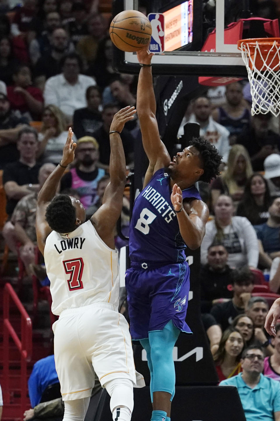 Charlotte Hornets guard Dennis Smith Jr. (8) blocks a shot to the basket by Miami Heat guard Kyle Lowry (7) during the first half of an NBA basketball game Thursday, Nov. 10, 2022, in Miami. (AP Photo/Marta Lavandier)