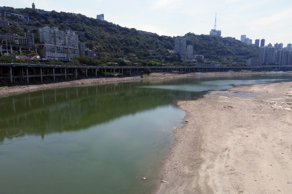 In this aerial photo, the lower than normal bank of the Jialing River is seen in southwestern China's Chongqing Municipality, Friday, Aug. 19, 2022. Ships crept down the middle of the Yangtze on Friday after the driest summer in six decades left one of the mightiest rivers shrunk to barely half its normal width and set off a scramble to contain damage to a weak economy in a politically sensitive year. (AP Photo/Olivia Zhang)