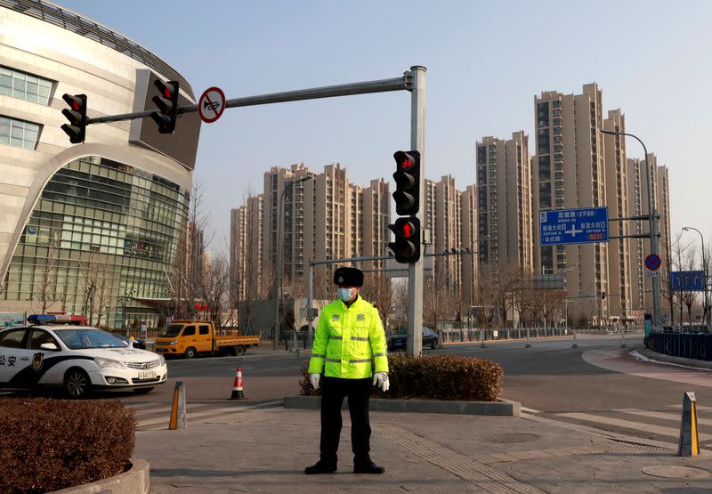 FILE PHOTO: Police guard a blocked-off street in a residential neighbourhood following new cases of the coronavirus disease (COVID-19) in the Tiangongyuan area of Daxing district in Beijing, China