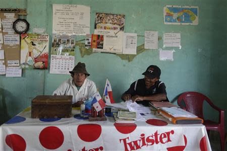 Caledonia's chief Aristoteles Cabu (L) and village Apolonio Arosemena, the village clerk. work on the village taxes at the tax office in the Caledonia island in the region of Guna Yala April 4, 2014. REUTERS/ Carlos Jasso