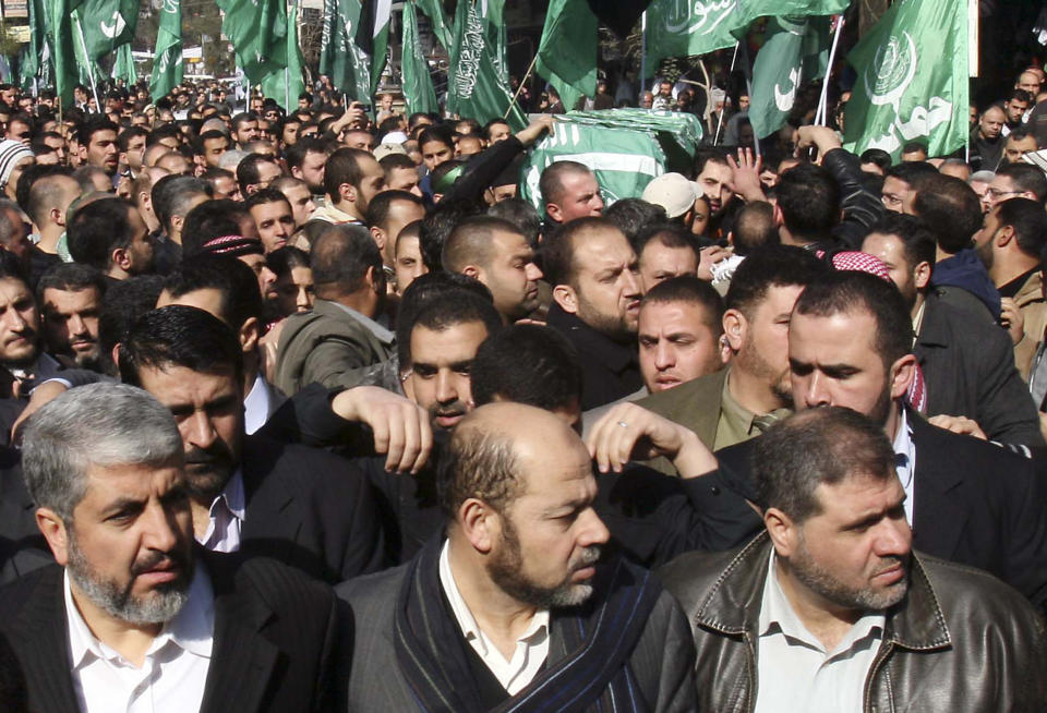 FILE - Hamas leader Khaled Mashaal, bottom left, marches as mourners carry the coffin of Mahmoud al-Mabhouh, one of the founders of Hamas' military wing who was killed in a Dubai hotel room in an operation attributed to the Mossad spy agency but never acknowledged by Israel, during his funeral procession at the Palestinian refugee camp of Yarmouk, near Damascus, Syria, Friday, Jan. 29, 2010. Prime Minister Benjamin Netanyahu and other Israeli leaders have repeatedly threatened to kill Hamas leaders following the group's deadly Oct. 7, 2023 cross-border attack that sparked the war in Gaza. Israel has a long history of assassinating its enemies, many carried out with precision airstrikes. (AP Photo/Bassem Tellawi, File)