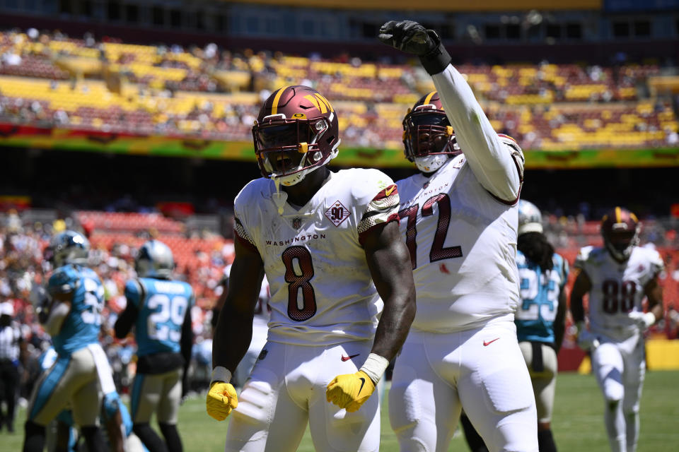 Washington Commanders running back Brian Robinson Jr. (8) celebrates his touchdown in front of offensive tackle Charles Leno Jr. (72) during the first half of a preseason NFL football game against the Carolina Panthers, Saturday, Aug. 13, 2022, in Landover, Md. (AP Photo/Nick Wass)