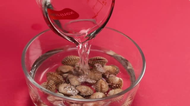 Pouring water onto cockles to wash them