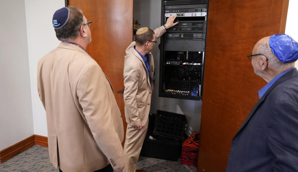 Rabbi Charlie Cytron-Walker, center, Jeff Cohen, left, and Lawrence Schwartz look on as the sound system is adjusted at Congregation Beth Israel in Colleyville, Texas, Thursday, April 7, 2022. Three months after an armed captor took four hostages, including the three men, at the Texas synagogue, the house of worship is reopening. (AP Photo/LM Otero)