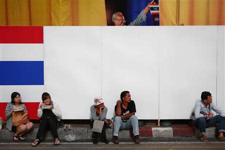 People listen to the speech inside an anti-government protester's encampment as a picture of protest leader Suthep Thaugsuban is seen behind them in central Bangkok February 28, 2014. REUTERS/Damir Sagolj