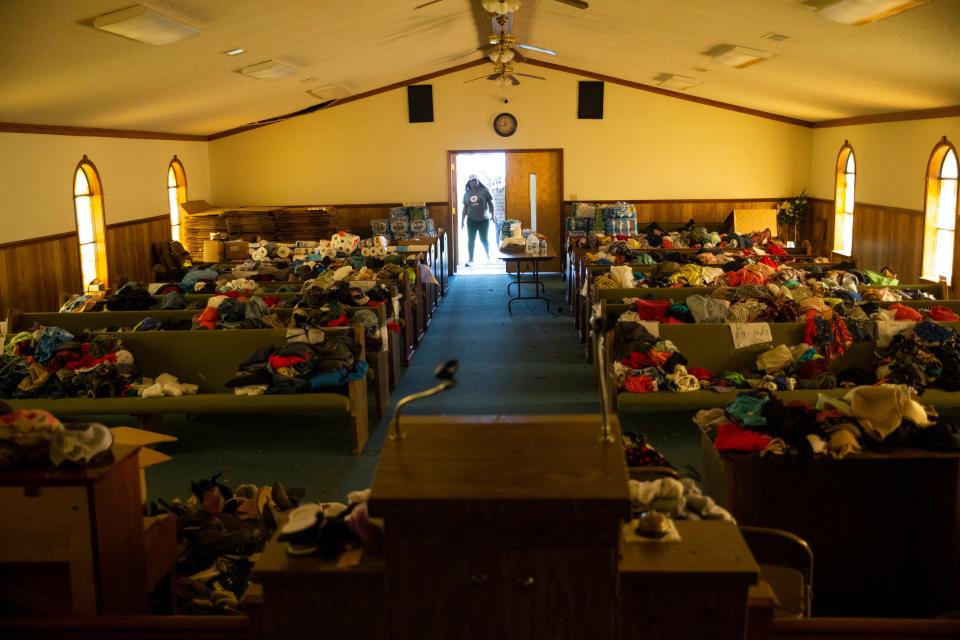 Felicia Tripp, senior disaster program manager with American Red Cross, walks into Little Mount Zion Missionary Baptist Church with Lewis Lampkin, a member of the church, in Silver City on Tuesday. The church is being used as overflow storage for clothes and other supplies collected by the community that residents may need.