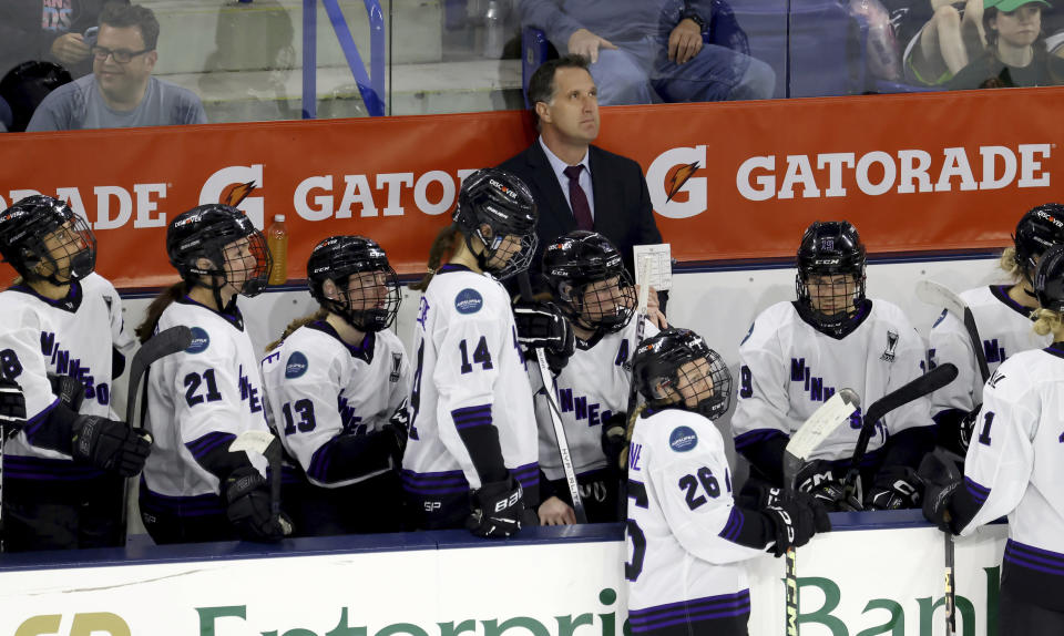 Minnesota coach Ken Klee watches a video screen during a challenge in the second period of Game 2 of a PWHL hockey championship series against Boston, Tuesday, May 21, 2024, in Lowell, Mass. (AP Photo/Mark Stockwell)