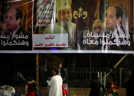 People walk by posters of Egypt's President Abdel Fattah al-Sisi with Egyptian Coptic Pope Tawadros II , Pope of the Coptic Orthodox Church of Alexandria, for the upcoming presidential election in Cairo, Egypt, March 8, 2018.REUTERS/Amr Abdallah Dalsh