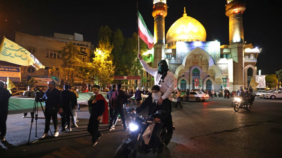 Demonstrators wave Iran's flag as they gather at Palestine Square in Tehran on April 14, 2024, after Iran launched a drone and missile attack on Israel. - Atta Kenare/AFP/Getty Images