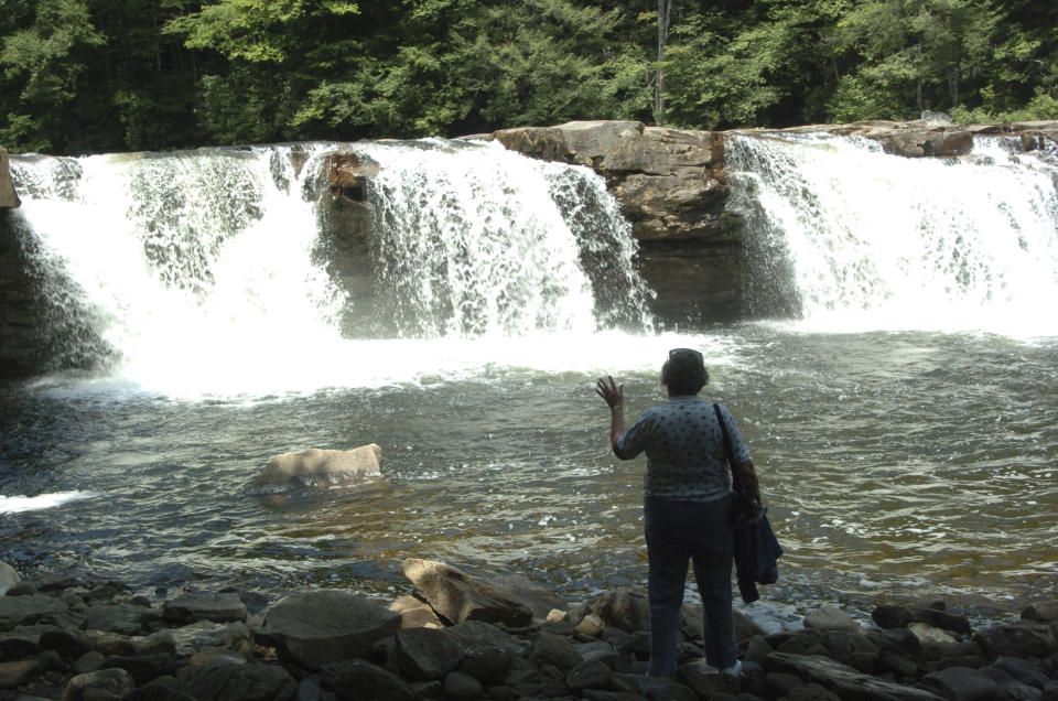 FILE - Eileen Lallone feels the mist from the waterfalls at the halfway point of the New Tygart Flyer scenic train ride on July 16, 2007, in Elkins, W.Va. A program offering cash and free outdoor adventures to remote workers to move to West Virginia with the hope of offsetting population losses has welcomed 143 new residents in the year since it launched, officials announced Tuesday, Nov. 29, 2022. (AP Photo/Dale Sparks, File)